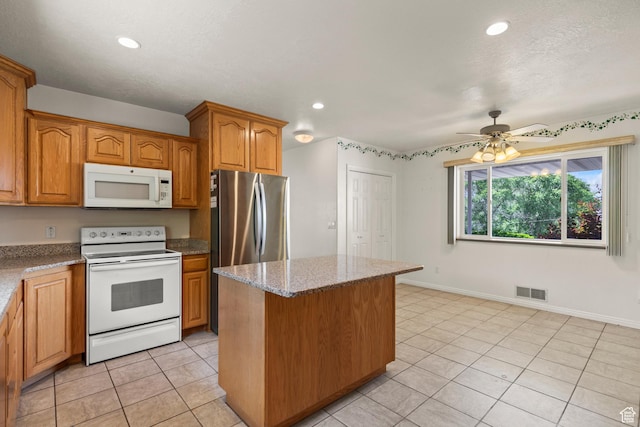 890 E Monroe Canyon Rd S, Monroe, UT 84754 - kitchen featuring white appliances, a kitchen island, light tile patterned floors, light stone countertops, and a ceiling fan