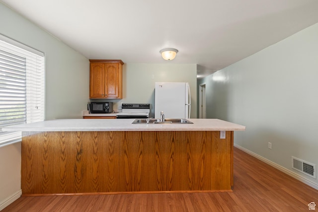 890 E Monroe Canyon Rd S, Monroe, UT 84754 - kitchen with white appliances, light wood-style flooring, light countertops, and brown cabinetry