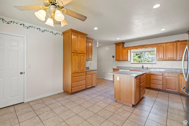890 E Monroe Canyon Rd S, Monroe, UT 84754 - kitchen featuring a kitchen island, recessed lighting, light tile patterned floors, brown cabinetry, and light stone countertops