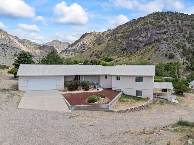 890 E Monroe Canyon Rd S, Monroe, UT 84754 - ranch-style home with driveway, a garage, a mountain view, a metal roof, and stucco siding