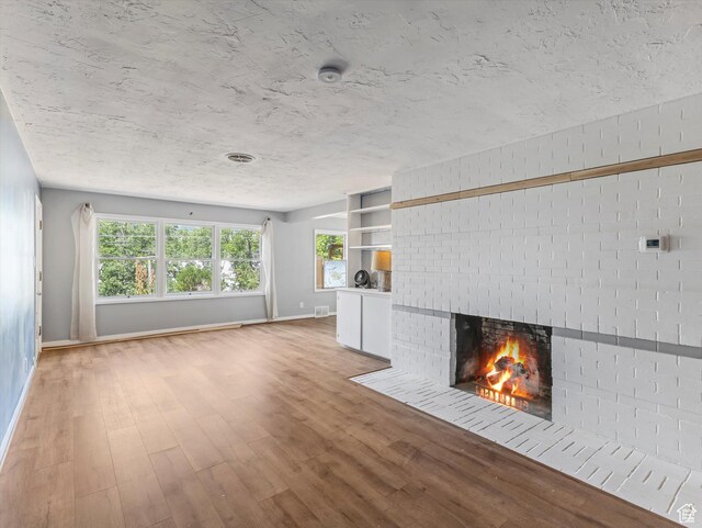 1815 E Hillcrest Ave, Salt Lake City, UT 84106 - unfurnished living room with a brick fireplace and light wood-type flooring