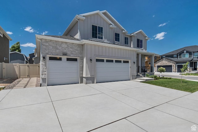 10948 S Samoa Dune Dr Unit 1027, South Jordan, UT 84009 - view of front of home with board and batten siding, concrete driveway, stone siding, a garage, and a gate