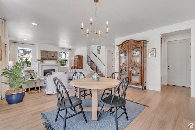 10948 S Samoa Dune Dr Unit 1027, South Jordan, UT 84009 - dining space featuring stairway, light wood finished floors, a warm lit fireplace, recessed lighting, and a chandelier
