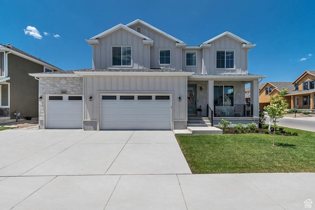 10948 S Samoa Dune Dr Unit 1027, South Jordan, UT 84009 - view of front of property with board and batten siding, a porch, stone siding, concrete driveway, and a front lawn