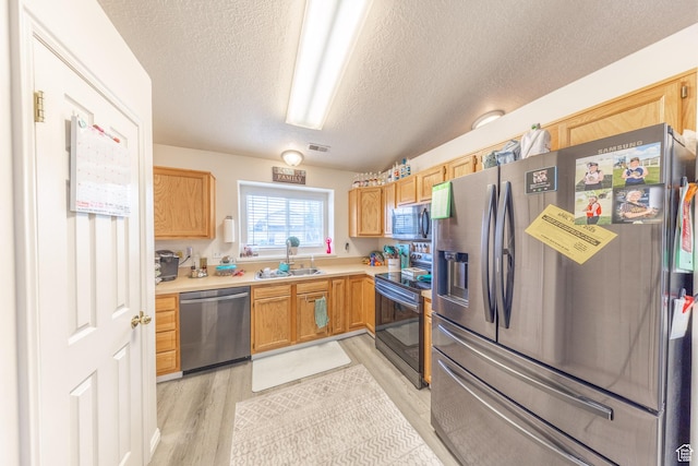 3762 W 4700 S, Roy, UT 84067 - kitchen featuring stainless steel appliances, light wood-style floors, light countertops, and a textured ceiling