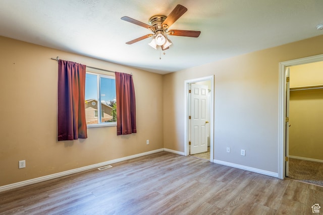 494 W 600 S, Tooele, UT 84074 - unfurnished bedroom featuring wood finished floors, a walk in closet, a closet, and ceiling fan