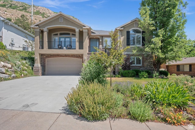 5155 S Alvera Dr E, Holladay, UT 84117 - view of front of home featuring stucco siding, a balcony, driveway, and an attached garage