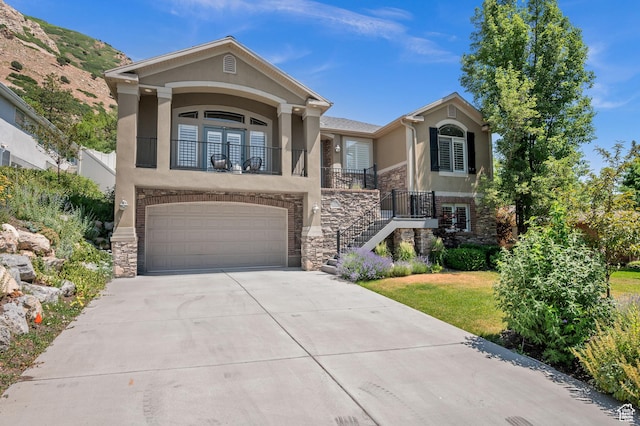 5155 S Alvera Dr E, Holladay, UT 84117 - view of front of home featuring stucco siding, stone siding, a garage, and driveway
