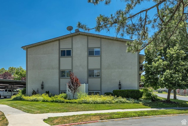 4851 S Woodbridge Dr Unit 38, Holladay, UT 84117 - view of home's exterior featuring stucco siding and a lawn