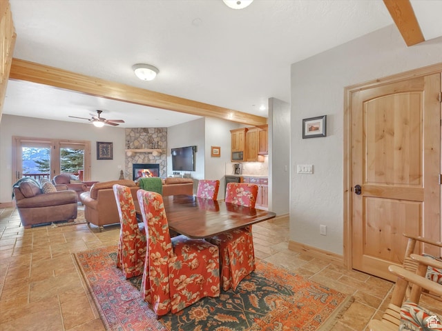 12069 N Sage Hollow Cir, Heber City, UT 84032 - dining area with beamed ceiling, stone tile floors, a ceiling fan, and a fireplace