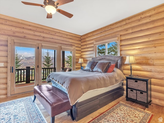 12069 N Sage Hollow Cir, Heber City, UT 84032 - bedroom with access to exterior, wood-type flooring, rustic walls, and ceiling fan
