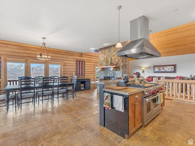 12069 N Sage Hollow Cir, Heber City, UT 84032 - kitchen with island exhaust hood, double oven range, rustic walls, stone tile flooring, and a fireplace