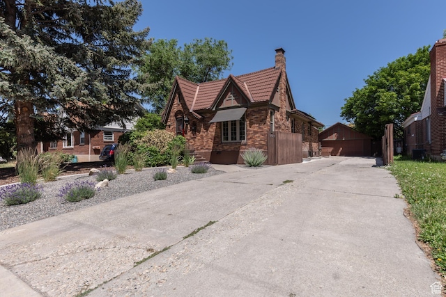 1723 E 2100 S, Salt Lake City, UT 84106 - view of front of home featuring a chimney, a tiled roof, brick siding, an outbuilding, and a garage