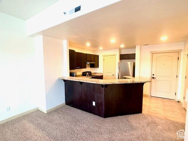 4276 S Main St W Unit 210, Murray, UT 84107 - kitchen with freestanding refrigerator, dark brown cabinets, a peninsula, light carpet, and recessed lighting