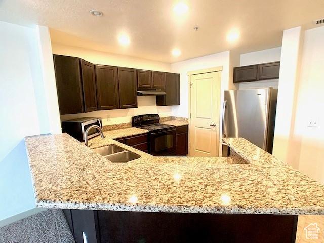 4276 S Main St W Unit 210, Murray, UT 84107 - kitchen featuring stainless steel appliances, dark brown cabinets, under cabinet range hood, light stone counters, and a peninsula