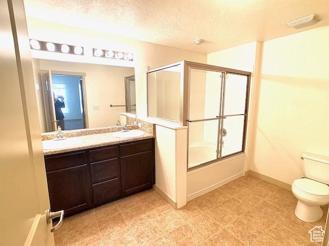4276 S Main St W Unit 210, Murray, UT 84107 - full bath with double vanity, shower / bath combination with glass door, and a textured ceiling