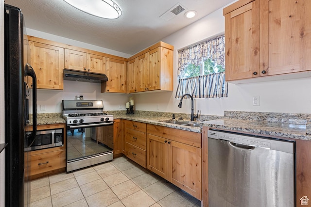 320 S 460 W, Hurricane, UT 84737 - kitchen featuring appliances with stainless steel finishes, under cabinet range hood, light stone counters, light tile patterned floors, and light brown cabinets