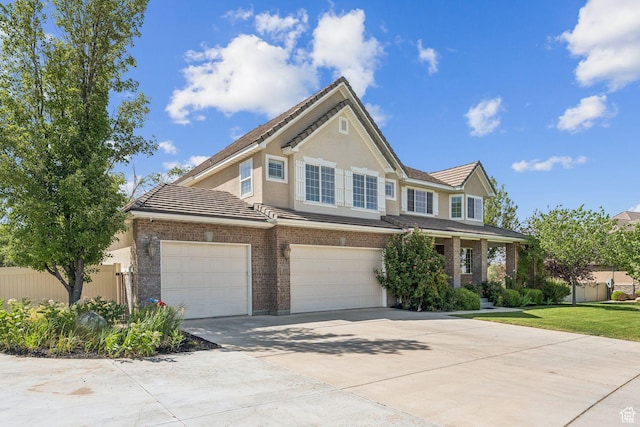 14318 S Butterfield Park Way, Herriman, UT 84096 - view of front of home featuring driveway, a tile roof, a garage, and stucco siding