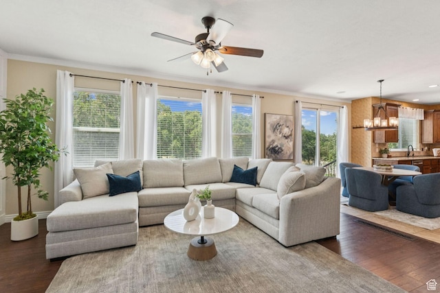 14318 S Butterfield Park Way, Herriman, UT 84096 - living room featuring healthy amount of natural light, wood finished floors, a chandelier, ceiling fan, and ornamental molding