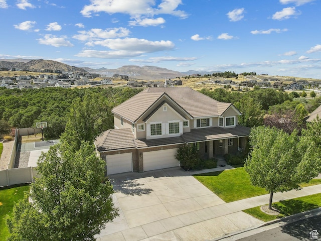 14318 S Butterfield Park Way, Herriman, UT 84096 - traditional home featuring a tiled roof, a garage, concrete driveway, a mountain view, and brick siding