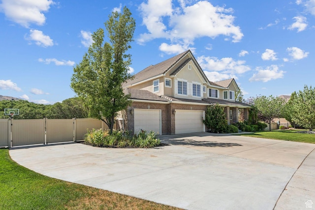 14318 S Butterfield Park Way, Herriman, UT 84096 - view of front of property featuring concrete driveway, a tiled roof, a gate, a garage, and brick siding