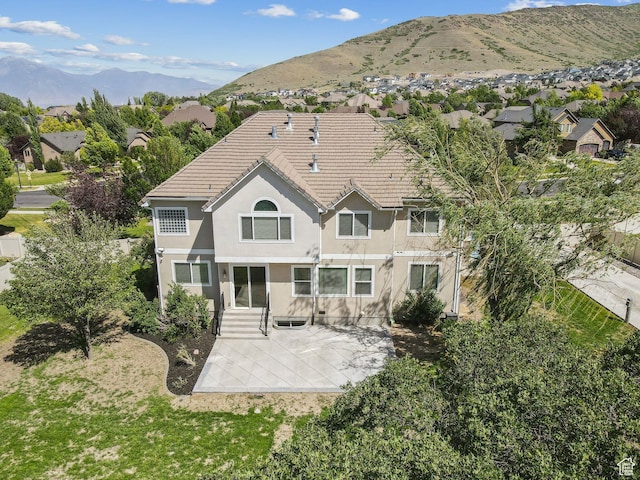 14318 S Butterfield Park Way, Herriman, UT 84096 - back of property with stucco siding, a patio area, a mountain view, a tiled roof, and a residential view