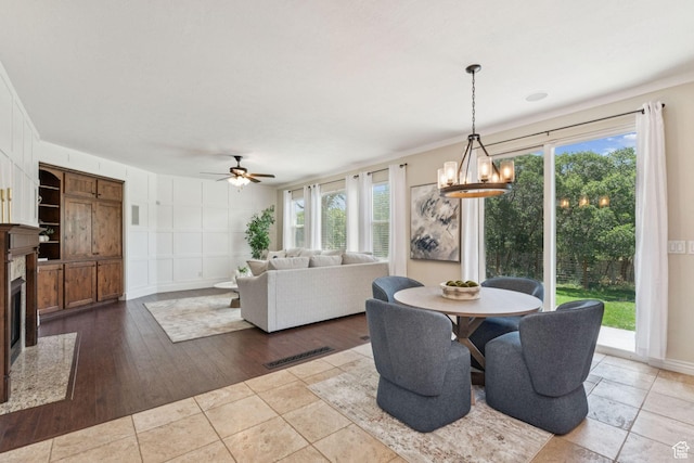 14318 S Butterfield Park Way, Herriman, UT 84096 - dining space with healthy amount of natural light, a ceiling fan, a high end fireplace, a chandelier, and crown molding