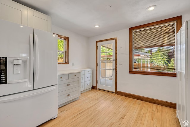 1252 E Bryan Ave S, Salt Lake City, UT 84105 - kitchen featuring white fridge with ice dispenser, light wood-style floors, recessed lighting, white cabinets, and light countertops