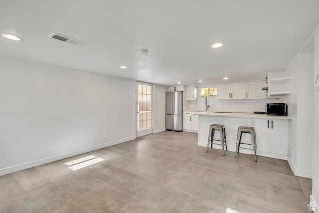 1252 E Bryan Ave S, Salt Lake City, UT 84105 - kitchen with freestanding refrigerator, open shelves, white cabinetry, light countertops, and recessed lighting