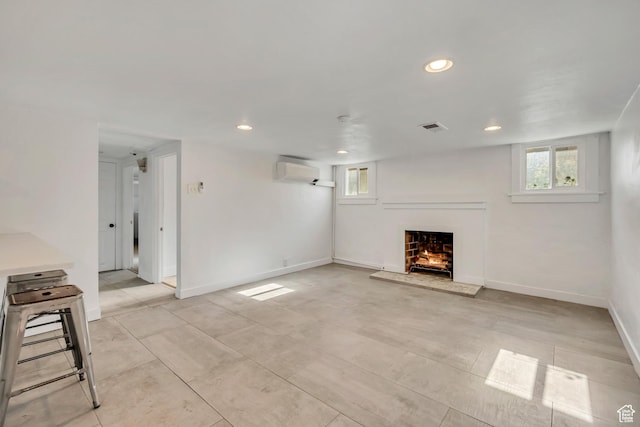 1252 E Bryan Ave S, Salt Lake City, UT 84105 - unfurnished living room featuring a wall mounted AC, a warm lit fireplace, recessed lighting, and healthy amount of natural light