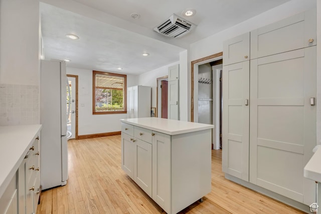 1252 E Bryan Ave S, Salt Lake City, UT 84105 - kitchen featuring freestanding refrigerator, light wood-style floors, light countertops, a kitchen island, and recessed lighting