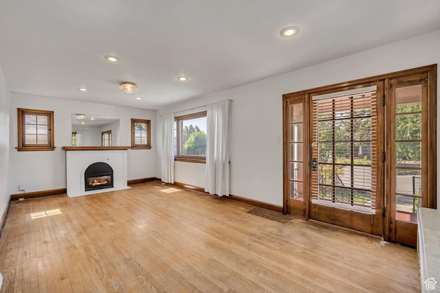 1252 E Bryan Ave S, Salt Lake City, UT 84105 - unfurnished living room featuring light wood finished floors, a lit fireplace, and recessed lighting