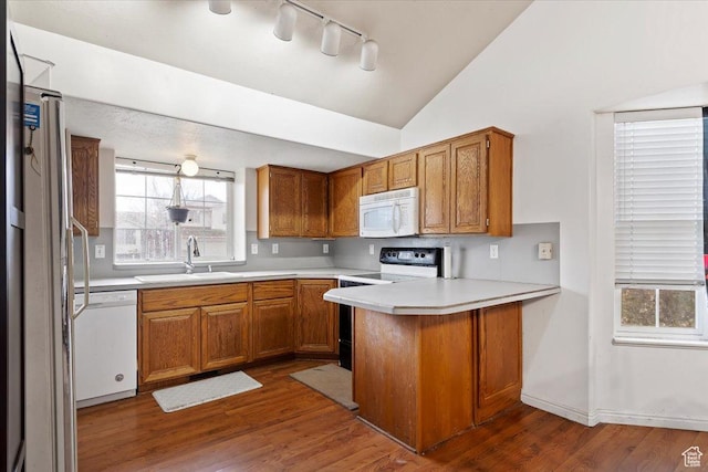 2826 W 4275 S, Roy, UT 84067 - kitchen with white appliances, a peninsula, brown cabinetry, lofted ceiling, and light countertops