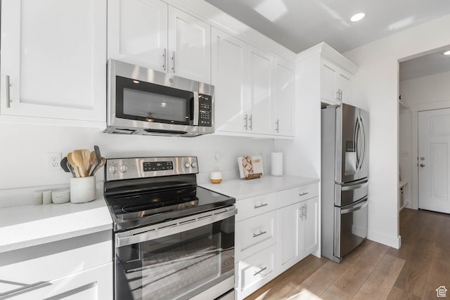 8151 St Cecilia St S, Eagle Mountain, UT 84005 - kitchen with stainless steel appliances, white cabinets, light wood-type flooring, and recessed lighting