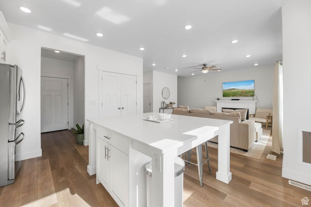 8151 St Cecilia St S, Eagle Mountain, UT 84005 - kitchen featuring freestanding refrigerator, a ceiling fan, a breakfast bar area, white cabinetry, and a center island