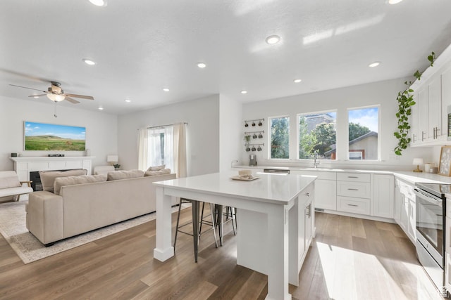 8151 St Cecilia St S, Eagle Mountain, UT 84005 - kitchen featuring stainless steel electric range, plenty of natural light, a kitchen island, light wood-style flooring, and recessed lighting