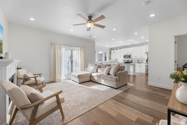 8151 St Cecilia St S, Eagle Mountain, UT 84005 - living room with a ceiling fan, light wood-type flooring, recessed lighting, and a fireplace