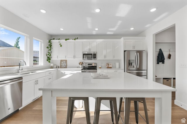 8151 St Cecilia St S, Eagle Mountain, UT 84005 - kitchen with appliances with stainless steel finishes, a kitchen bar, a center island, white cabinetry, and recessed lighting