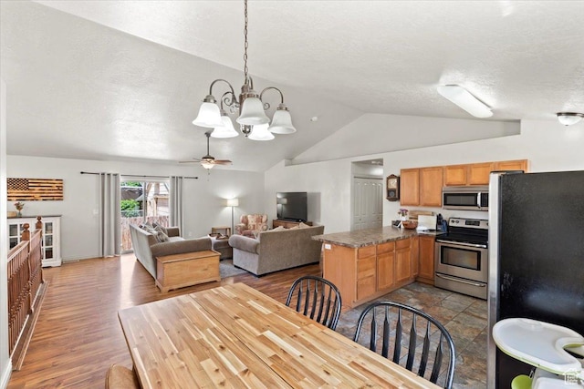 1544 Liberty Ave, Ogden, UT 84404 - dining area featuring vaulted ceiling, a chandelier, wood finished floors, ceiling fan, and a textured ceiling
