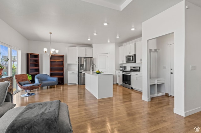 1268 S Raintree Ln, Santaquin, UT 84655 - kitchen with stainless steel appliances, open floor plan, a chandelier, light wood-style flooring, and white cabinets
