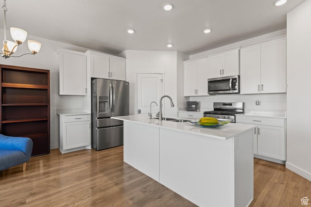 1268 S Raintree Ln, Santaquin, UT 84655 - kitchen with stainless steel appliances, light countertops, a chandelier, light wood-style floors, and a kitchen island with sink