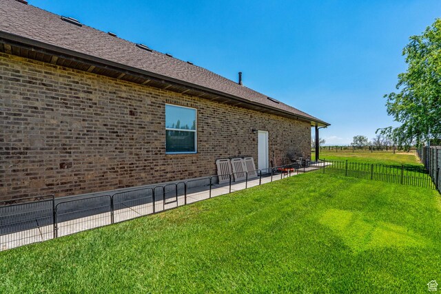 6613 W 200 N, Ogden, UT 84404 - view of home's exterior featuring a fenced backyard, brick siding, roof with shingles, and a patio area