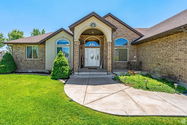 6613 W 200 N, Ogden, UT 84404 - doorway to property featuring brick siding and a lawn