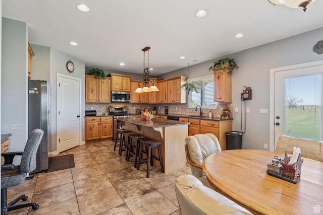 6613 W 200 N, Ogden, UT 84404 - kitchen featuring stainless steel appliances, dark countertops, a kitchen breakfast bar, decorative backsplash, and a center island