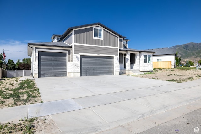 361 E Ventura Blvd, Tooele, UT 84074 - view of front of home featuring board and batten siding, driveway, an attached garage, a mountain view, and a garage