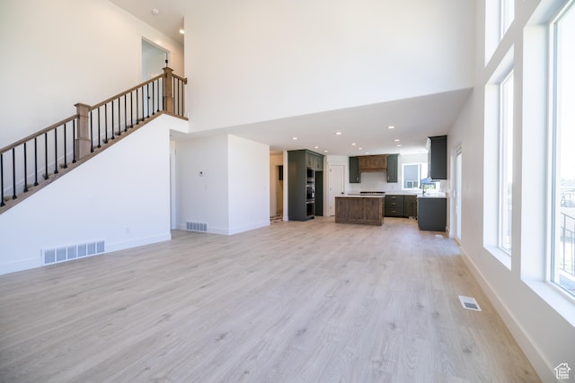 361 E Ventura Blvd, Tooele, UT 84074 - unfurnished living room with a towering ceiling, light wood finished floors, stairway, and recessed lighting