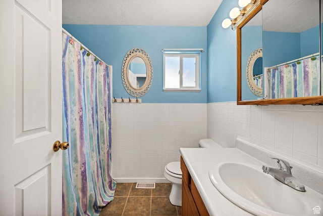345 E 2475 N, North Logan, UT 84341 - bathroom with tile patterned flooring, vanity, tile walls, and a wainscoted wall