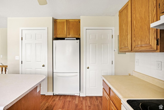345 E 2475 N, North Logan, UT 84341 - kitchen featuring freestanding refrigerator, wood finished floors, light countertops, and brown cabinets