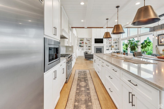 953 E 1000 N, American Fork, UT 84003 - kitchen with stainless steel appliances, a tiled fireplace, open floor plan, light wood finished floors, and white cabinets