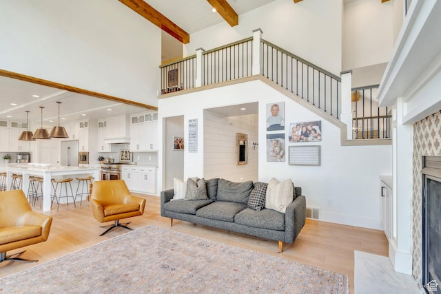 953 E 1000 N, American Fork, UT 84003 - living room with a towering ceiling, light wood-style floors, a high end fireplace, beam ceiling, and stairs
